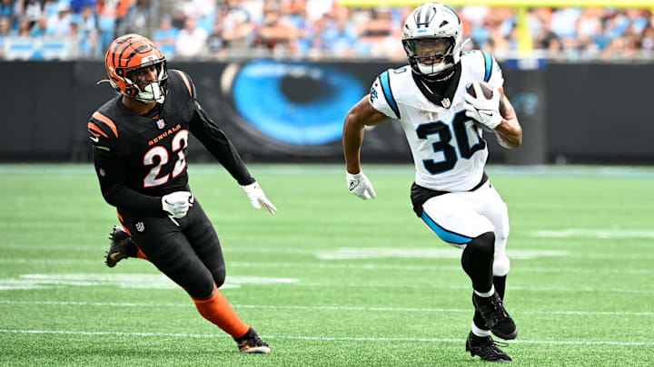 Sep 29, 2024; Charlotte, North Carolina, USA; Carolina Panthers running back Chuba Hubbard (30) with the ball as Cincinnati Bengals safety Geno Stone (22) defends in the second quarter at Bank of America Stadium. Mandatory Credit: Bob Donnan-Imagn Images